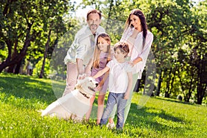 Photo of sweet charming preteen boy girl mother father dressed casual outfit playing pappy smiling outside city park