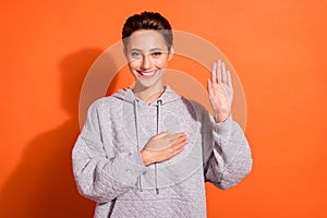 Photo of sweet charming young lady wear grey sweatshirt smiling listening anthem isolated orange color background