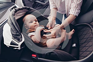 Photo of sweet cute mommy son dressed casual clothes buckling up seatbelt inside auto transport