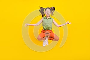 Photo of sweet funky student girl wear green shirt smiling jumping high practicing yoga isolated yellow color background