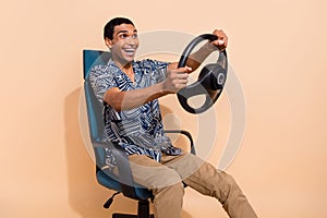 Photo of sweet handsome man wear print shirt driving car fast smiling isolated beige color background