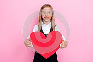 Photo of sweet lovely positive girl hold big red paper heart figure show demonstrate present you isolated on pink color
