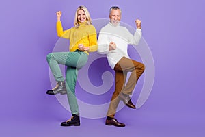 Photo of sweet lucky mature wife husband wear knitted pullovers smiling rising fists  purple color background