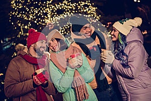 Photo of sweet positive four buddies wear windbreakers enjoying xmas hot tasty beverages outside urban market park