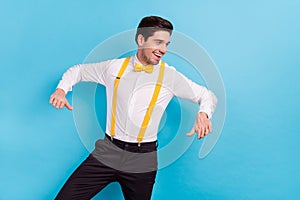 Photo of sweet pretty guy wear yellow suspenders white shirt having fun isolated blue color background photo