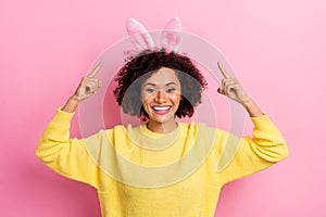 Photo of sweet pretty woman dressed kitted pullover easter headband pointing up empty space isolated pink color
