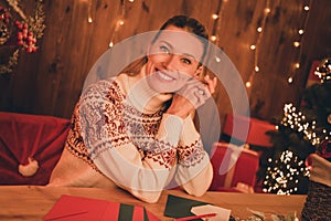 Photo of sweet pretty young lady dressed print pullover writing christmas wish list smiling indoors room home house