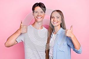 Photo of sweet shiny young couple wear casual clothes smiling embracing showing thumbs up isolated pink color background