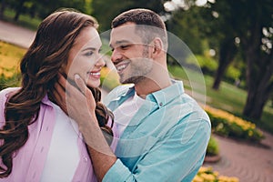 Photo of sweet shiny young wife husband dressed pastel shirts walking kissing enjoying sunshine outdoors backyard