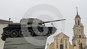 Photo of T-34 tank on the catholic church background. War and peace concept.