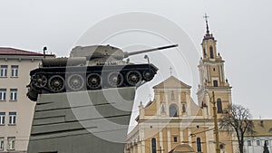 Photo of T-34 tank on the catholic church background. War and peace concept