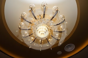 A bottom up angle photo taken on a chandelier lighting unit dispersing warmth yellow lights photo