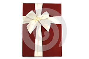 A photo taken on a bright red gift Box bind by a white beige ribbon bow photo