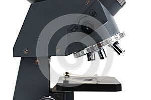 A close up side view of a laboratory multiple high magnification microscope toy replica against a white backdrop