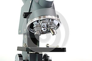 A close up laboratory multiple high magnification microscope toy replica against a white backdrop