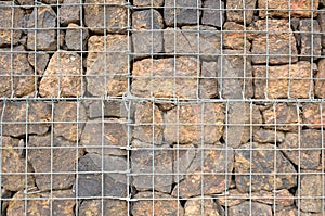 A natural barrier wall made of compacted rock bricks and meshed wire photo