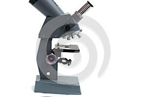 Side view of a laboratory multiple high magnification microscope toy replica against a white backdrop