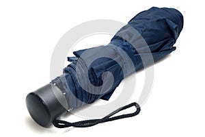 A photo taken on a small shorter dark blue brolly umbrella white backdrop