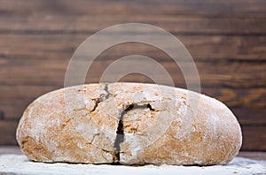 Photo of tasty fresh bread loaf on the wonderful brown wooden ba