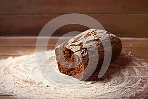 Photo of tasty fresh loaf of bread on the wonderful brown wooden