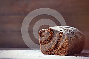 Photo of tasty fresh loaf of bread on the wonderful brown wooden