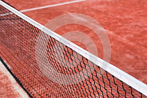 Photo of tennis net at red court