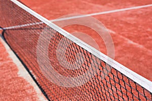 Photo of tennis net at red court
