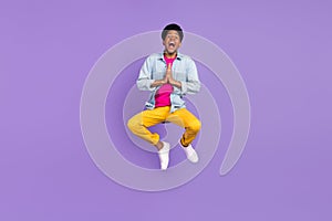 Photo of thankful grateful guy jump plead hold hands wear blue shirt pants shoes isolated purple color background