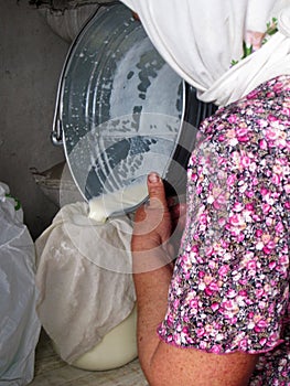 Photo on theme of milkmaid woman pouring milk