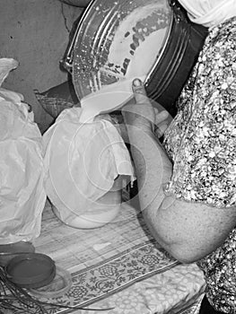 Photo on theme of milkmaid woman pouring milk