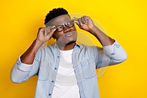 Photo of think millennial brunet guy look pomo wear eyewear jeans shirt isolated on yellow color background photo