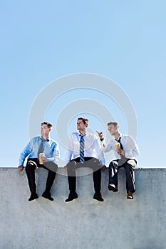 Photo of thoughtful businessmen sitting and relaxing on rooftop