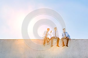 Photo of thoughtful businessmen sitting and relaxing on rooftop