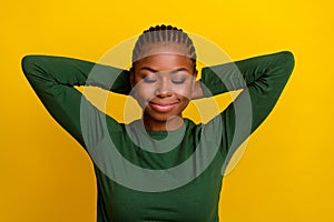 Photo of thoughtful dreamy young woman wear green shirt arms behind head isolated yellow color background