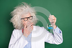 Photo of thoughtful minded crazy mad scientist thinking about new experiment isolated on green color background