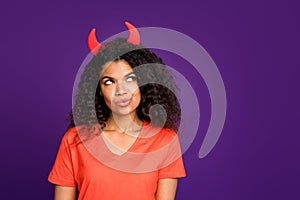 Photo of thoughtful wondered curly wavy girlfriend with horns out of her head thinking on some diabolic things in orange