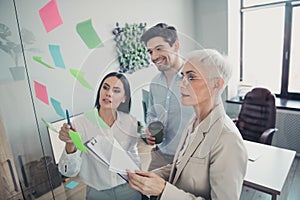 Photo of three business people have startup development meeting point ideas in workstation workplace