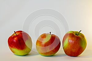Three isolated red and green apples on the white background