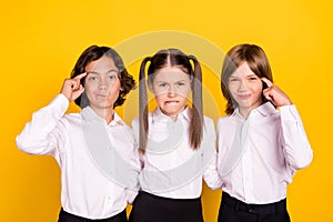 Photo of three minded schoolchildren hard brainstorming wear white shirt isolated yellow color background