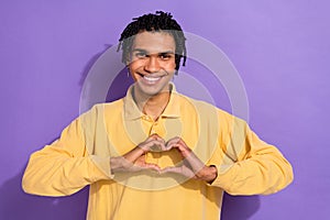 Photo of toothy beaming person with cornrows wear stylish shirt fingers showing heart symbol on chest isolated on purple