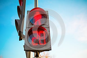 Photo of traffic light with red man, close-up on background of blue sky.