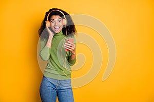 Photo of trendy stylish curly wavy cheerful positive girl millennial expressing excitement on face in jeans denim green