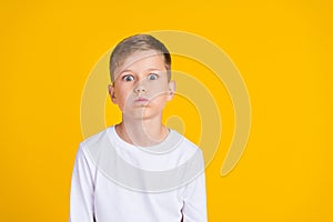 Photo of tricky impressed boy wear white shirt bloated cheeks empty space isolated yellow color background