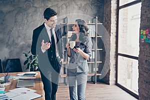 Photo of two business people having coffee break standing workstation office communicating dressed formal wear suits