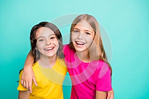 Photo of two friendly kind amazing beautiful girls being glad to be photographed while isolated with teal background photo