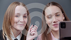 Photo of two girls bloggers talking with followers on gray background