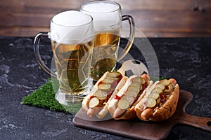 Photo of two glasses of beer, hot dogs, soccer ball