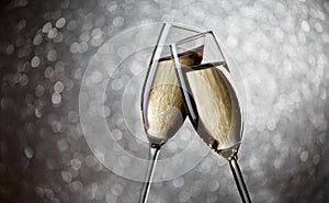 Photo of two glasses with champagne on gray background,