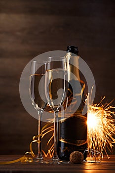 Photo of two glasses with wine, bottles, cork, burning Bengal fire