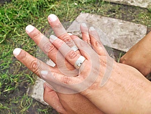 Interlaced hands with engagement rings. photo
